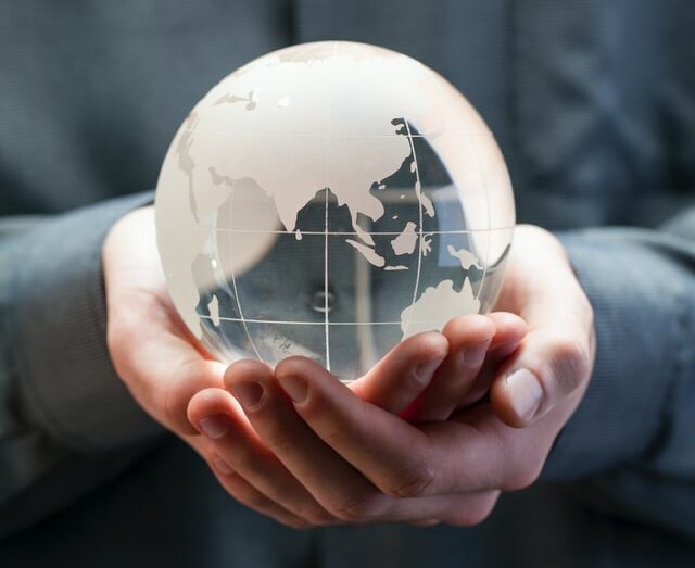 two hands holding a glass globe